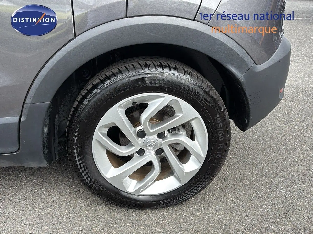 Gros plan sur la roue avant droite d'un Opel Crossland X gris Pierre de Lune métal avec jante alliage 16 pouces.