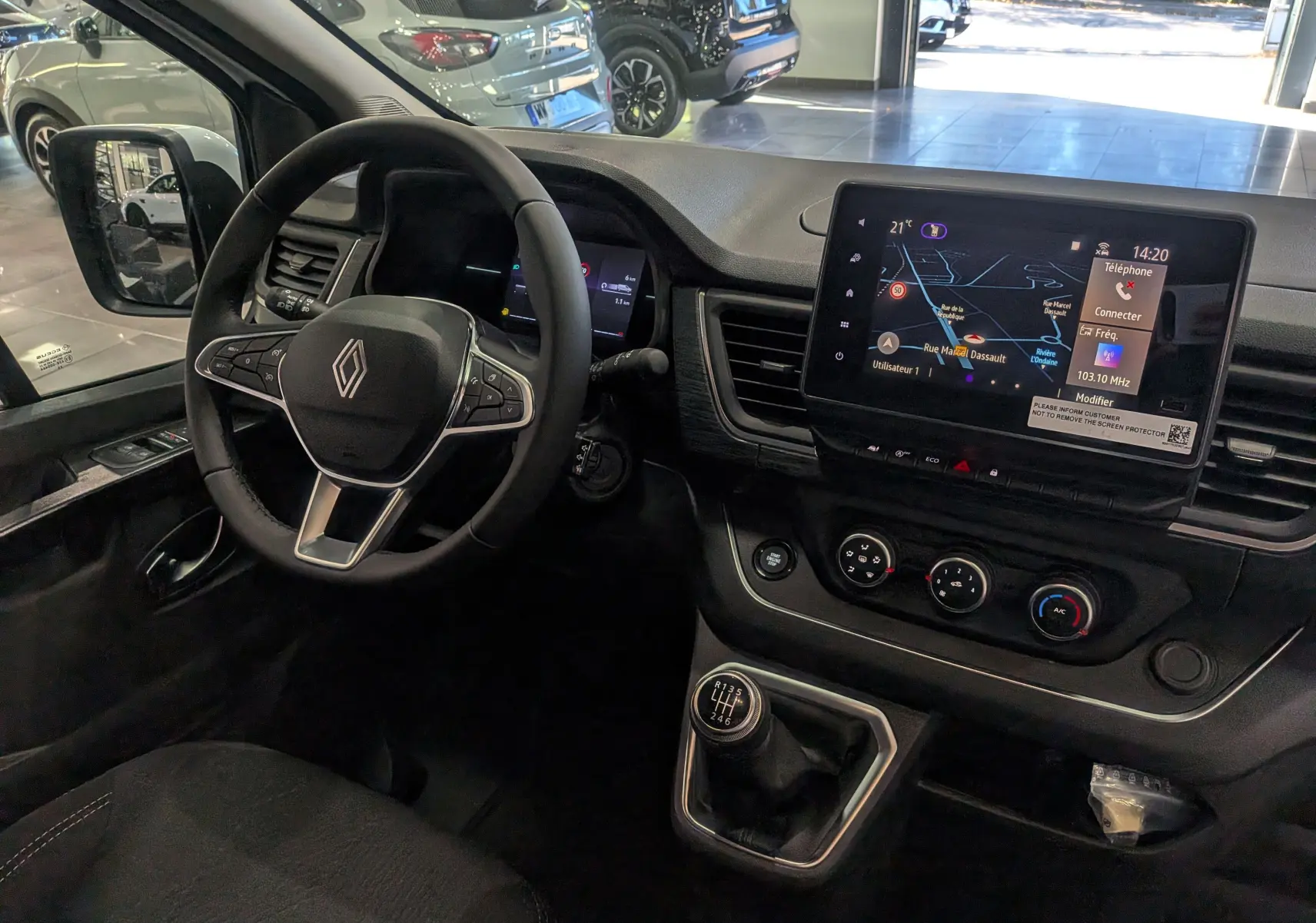 Intérieur du Renault Trafic Combi 2025, vue du poste de conduite avec volant multifonction et écran tactile central.