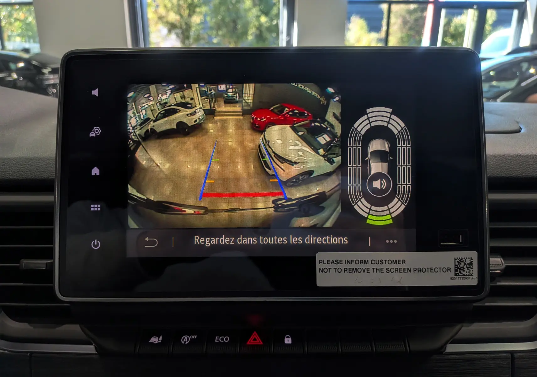 Écran tactile du système multimédia montrant la caméra de recul et les aides au stationnement du Renault Trafic Combi blanc.