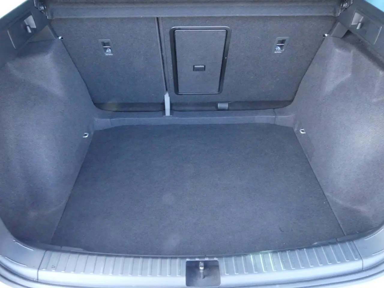 Coffre spacieux du SEAT Ateca gris clair 2023, vue intérieure arrière avec tapis et fixations ISOFIX visibles.