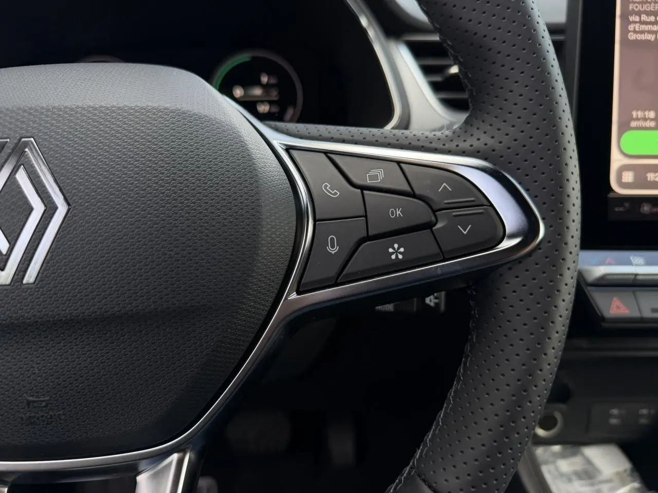 Gros plan sur le volant perforé noir du Renault Captur 2026 avec commandes intégrées et logo Renault central.