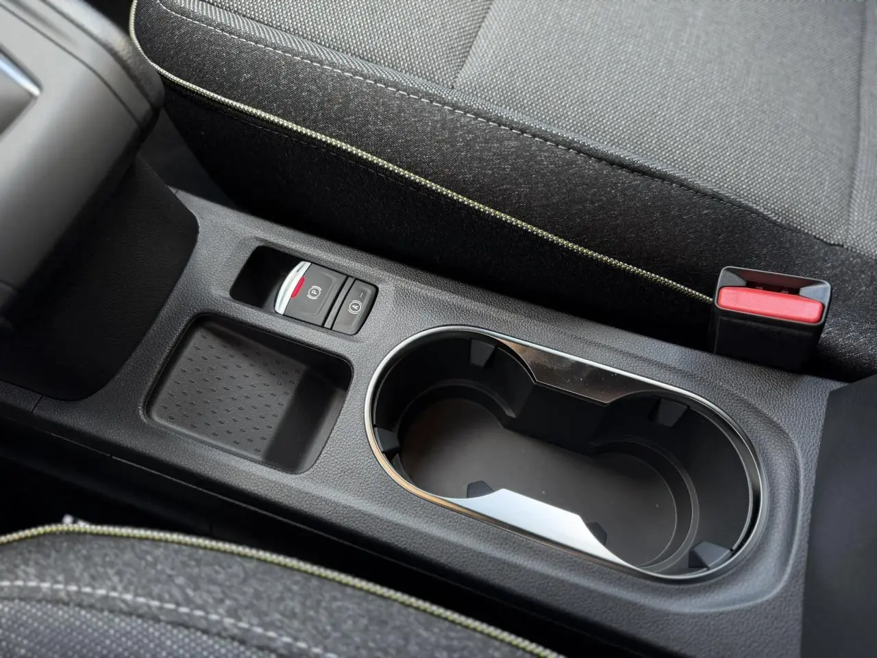 Gros plan sur la console centrale noire du Renault Captur 2026 avec porte-gobelets et frein de parking électrique.