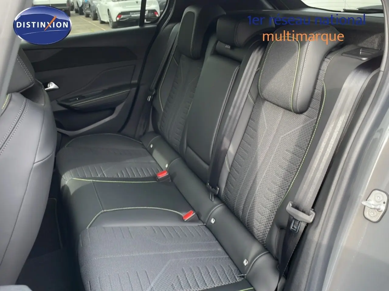 Vue intérieure côté arrière droit montrant la banquette en tissu et cuir noir avec surpiqûres vertes du Peugeot 308 gris selenium 2026.