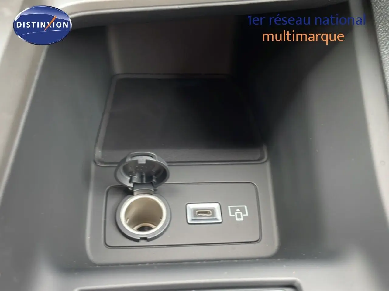 Prise allume-cigare et port USB-C dans la console centrale d'une Peugeot 308 gris selenium hybride 2026.