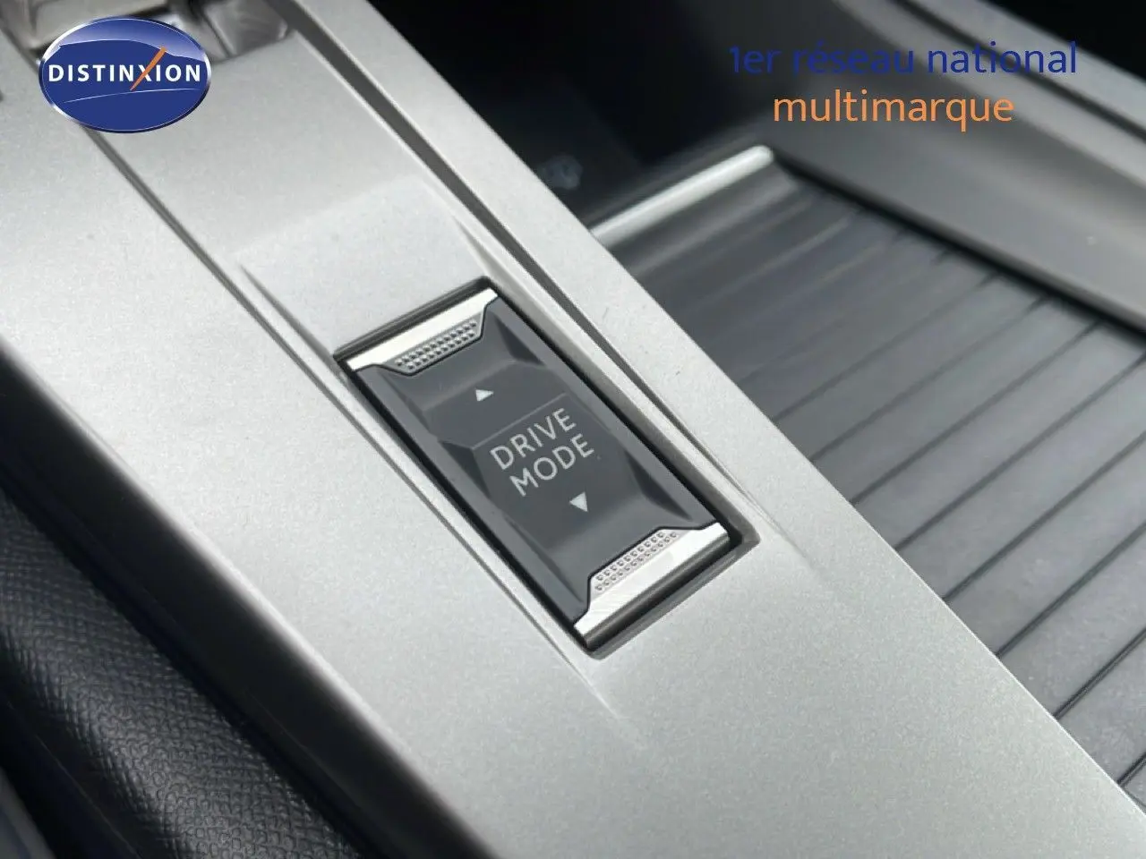 Gros plan sur le bouton Drive Mode dans la console centrale grise du Peugeot 308 1.2 Hybrid 145ch GT 2026.