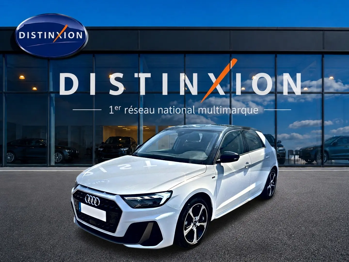 Audi A1 Sportback blanc et noir vue 3/4 avant droit devant une vitrine Distinxion, jantes alu et toit noir contrasté.