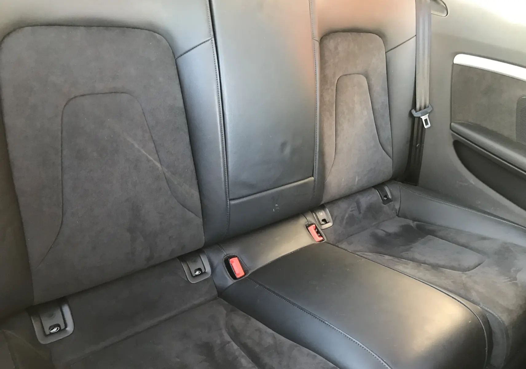 Vue rapprochée des sièges arrière en cuir noir et alcantara de l'Audi A5 Coupé gris dauphin de 2012.