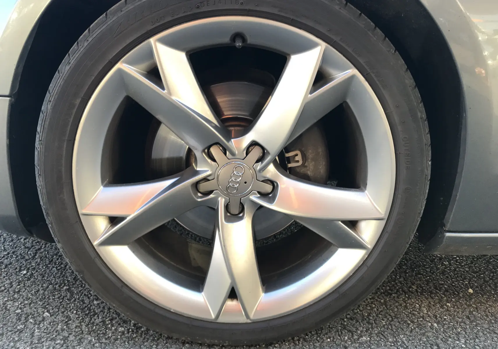 Gros plan sur la jante alliage argentée à cinq branches de l'Audi A5 Coupé gris dauphin.