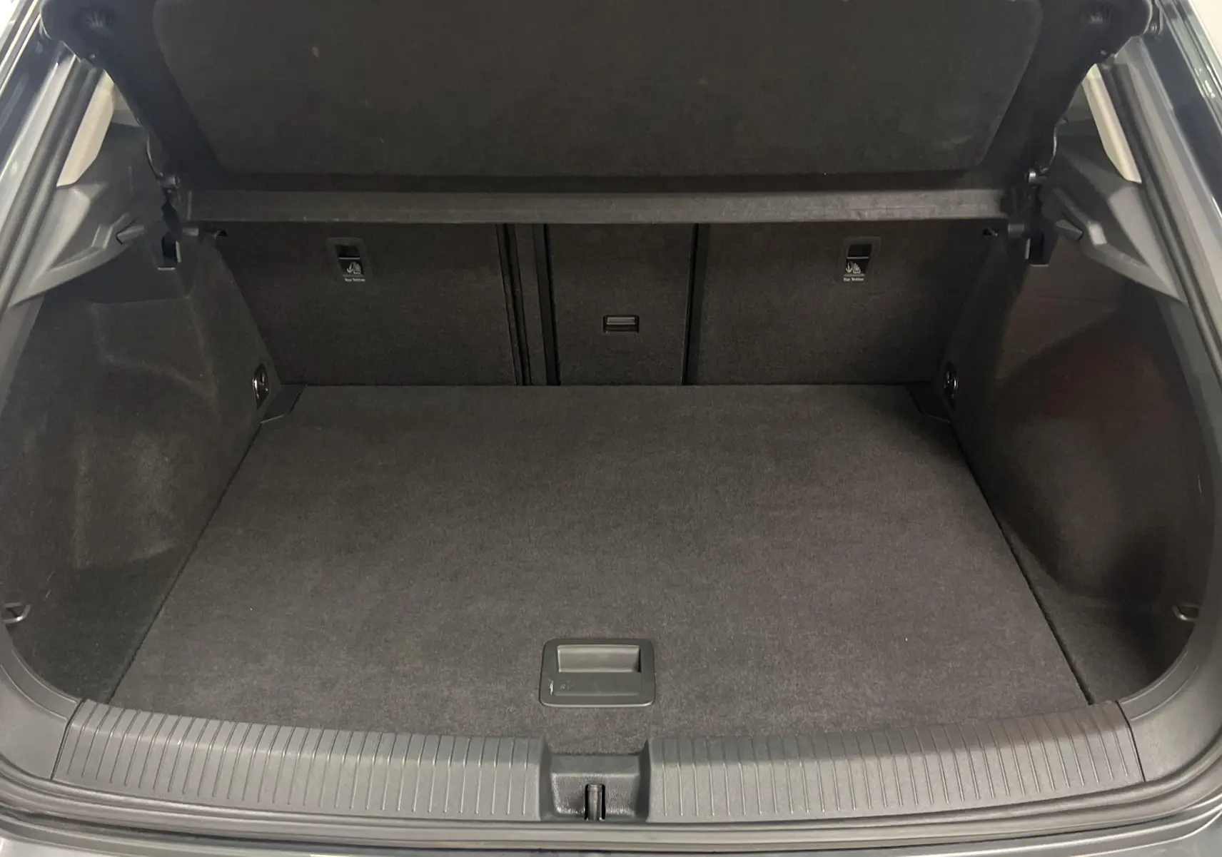 Coffre ouvert du Volkswagen T-Roc gris Indium 2024, montrant un espace de chargement propre et spacieux.
