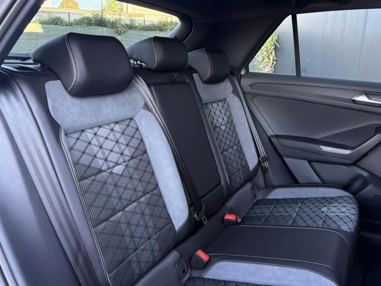 Vue latérale droite des sièges arrière en cuir et tissu gris et noir du Volkswagen T-Roc 2.0 TDI R-Line 2025 avec toit ouvrant