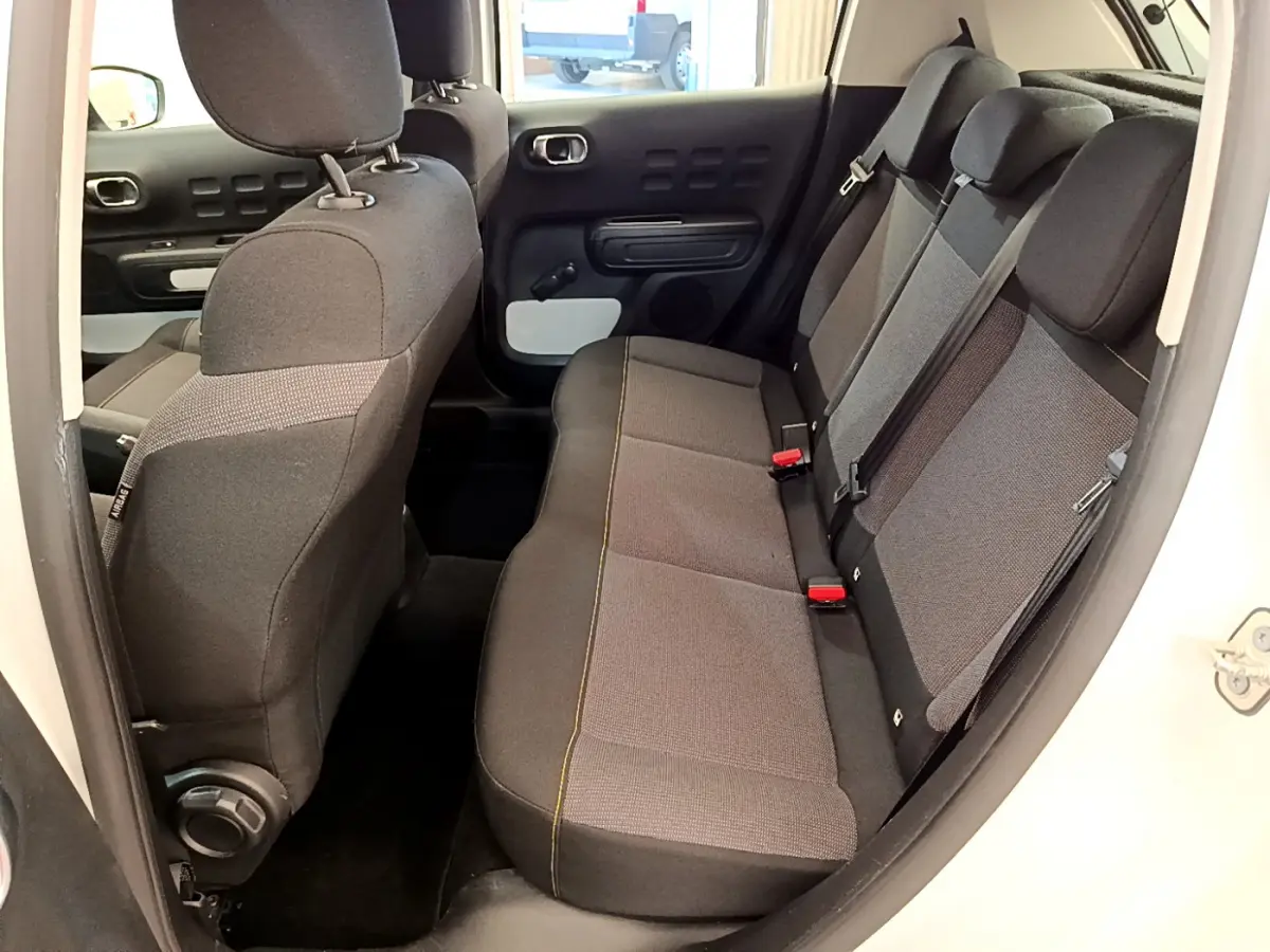 Vue intérieure côté droit sur la banquette arrière grise et noire de la Citroën C3 PureTech 82 blanche de 2019.