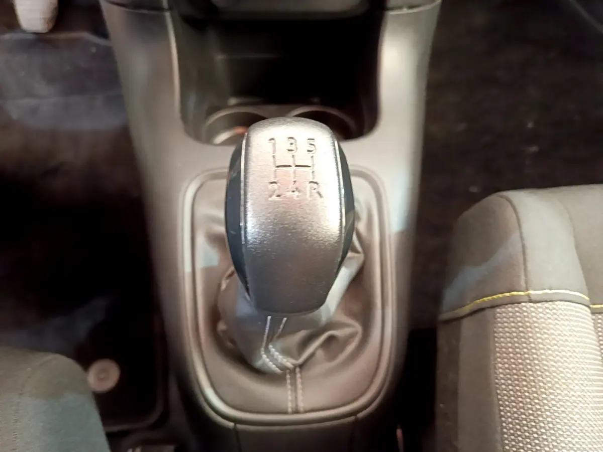 Le levier de vitesse manuel gris de la Citroën C3 PureTech 82 S&S, vu de dessus, avec siège tissu à couture jaune.