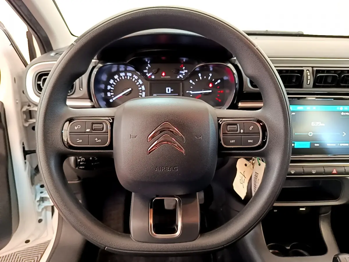 Volant multifonctions Citroën C3 PureTech 82 blanc, vue frontale du tableau de bord avec écran tactile et compteur digital.