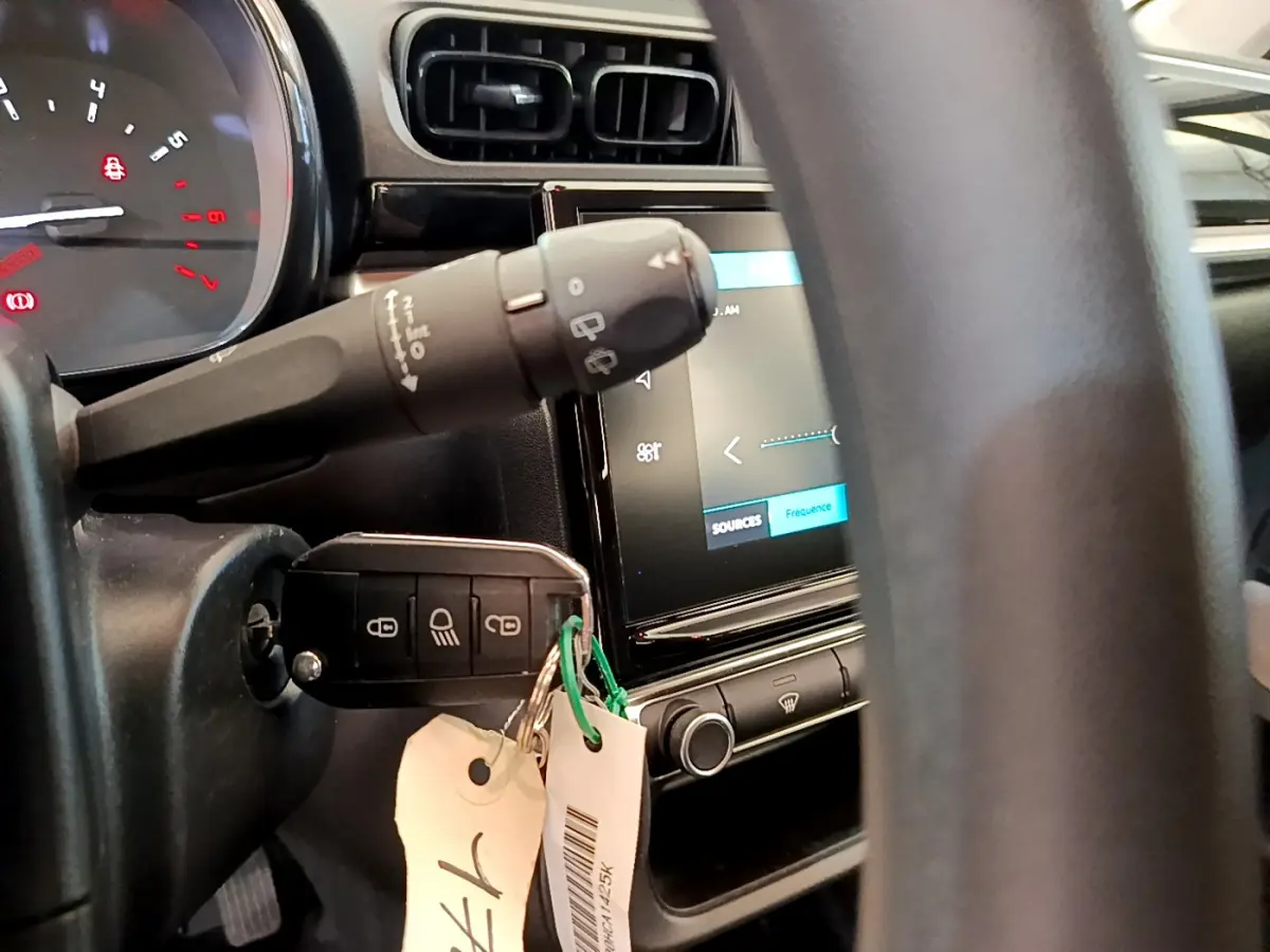 Vue rapprochée du tableau de bord et du volant de la Citroën C3 2019 avec clé insérée et écran tactile allumé.