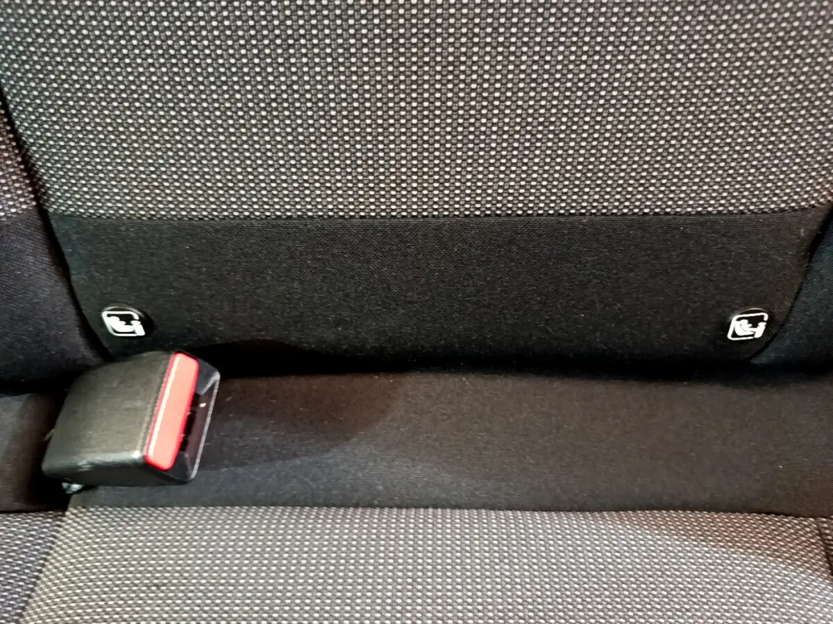 Détail de la banquette arrière noire et grise avec fixation Isofix et boucle de ceinture sur Citroën C3 blanche.