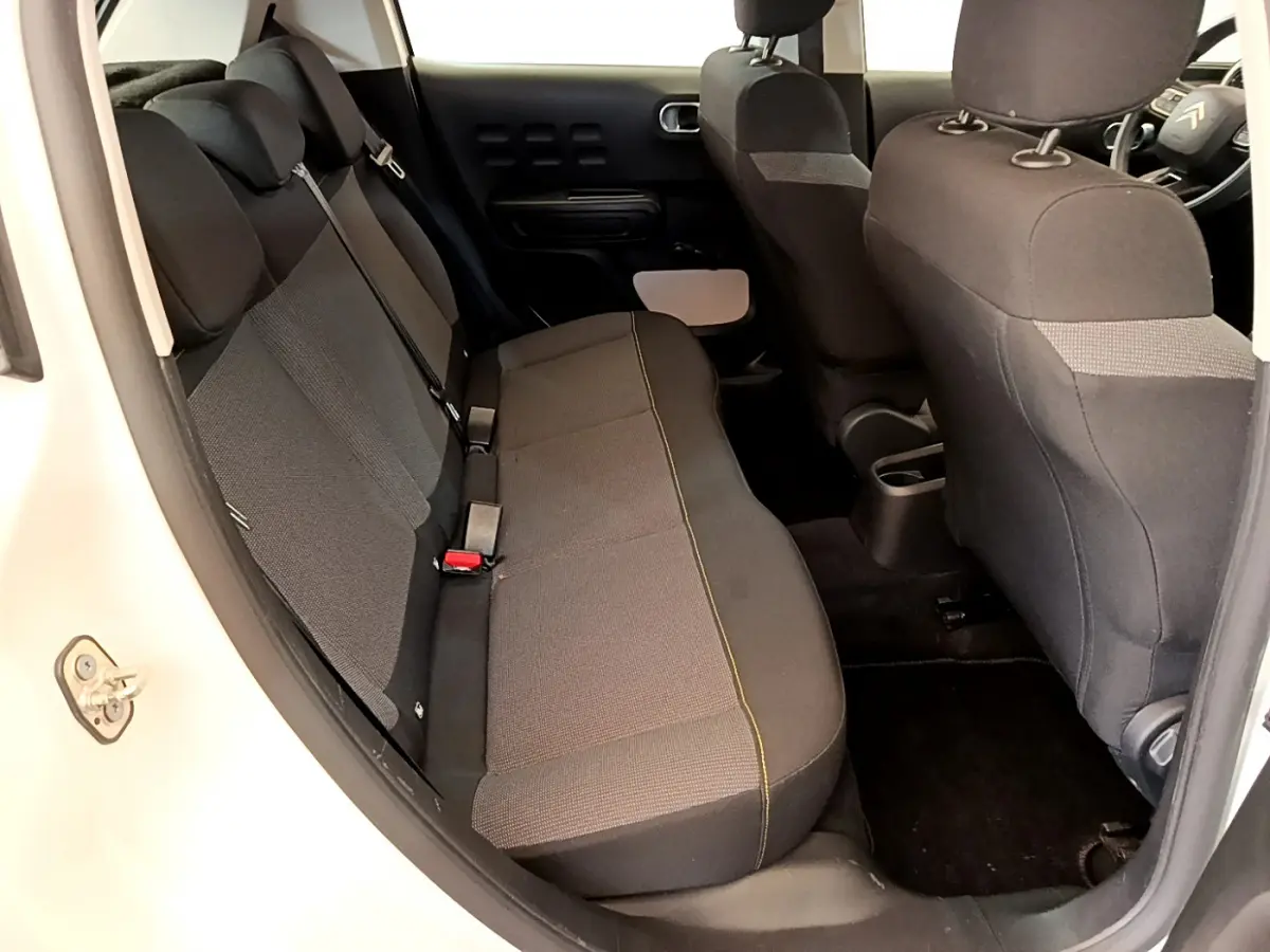 Vue intérieure côté gauche montrant la banquette arrière noire et grise de la Citroën C3 blanche de 2019.