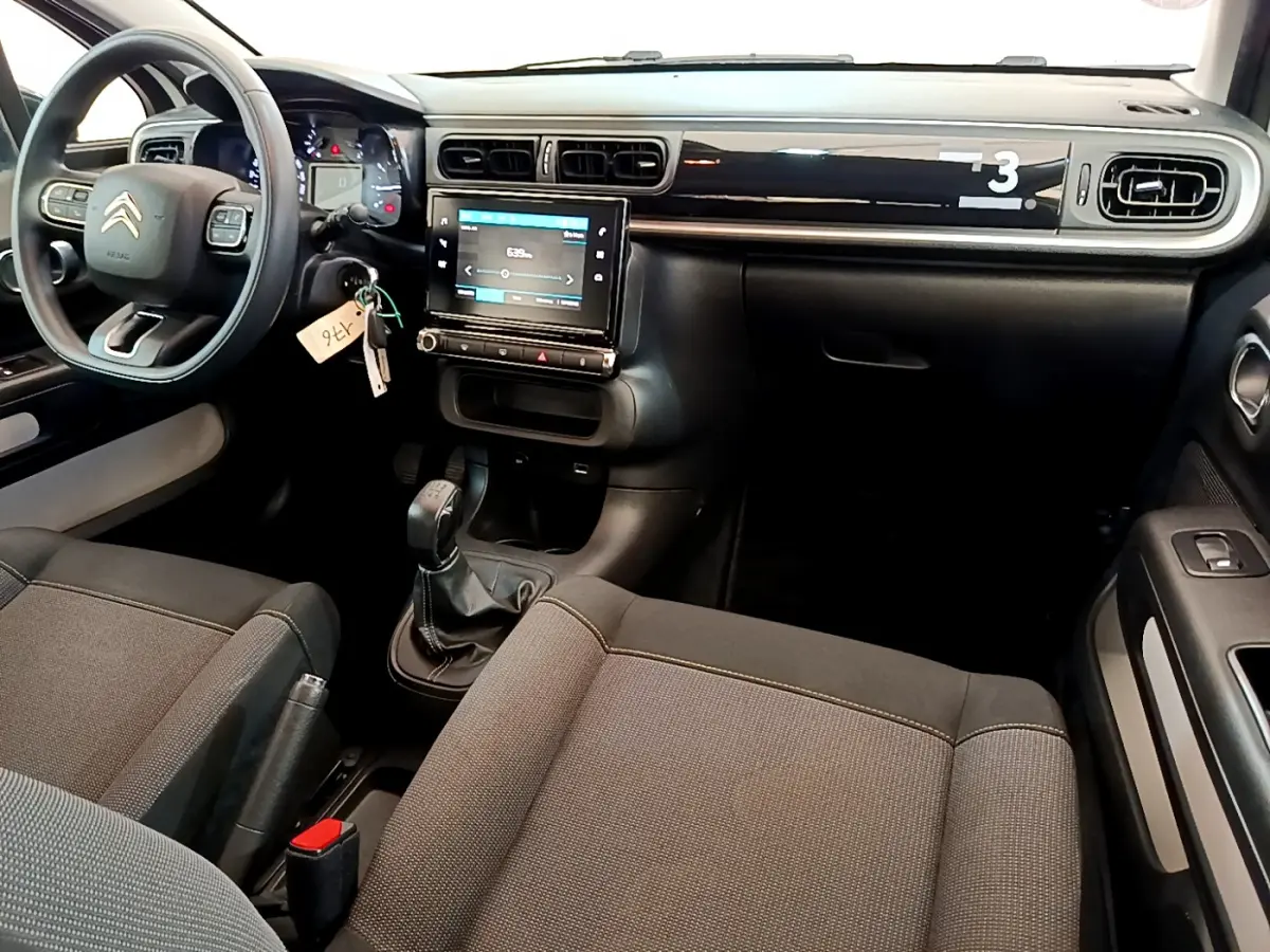 Intérieur de la Citroën C3 PureTech 82 2019 vu côté conducteur, tableau de bord noir avec écran tactile central.