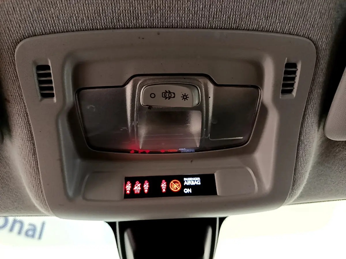 Panneau de contrôle intérieur au plafond de la Citroën C3 blanche, avec voyants de ceinture et airbag passager allumés.