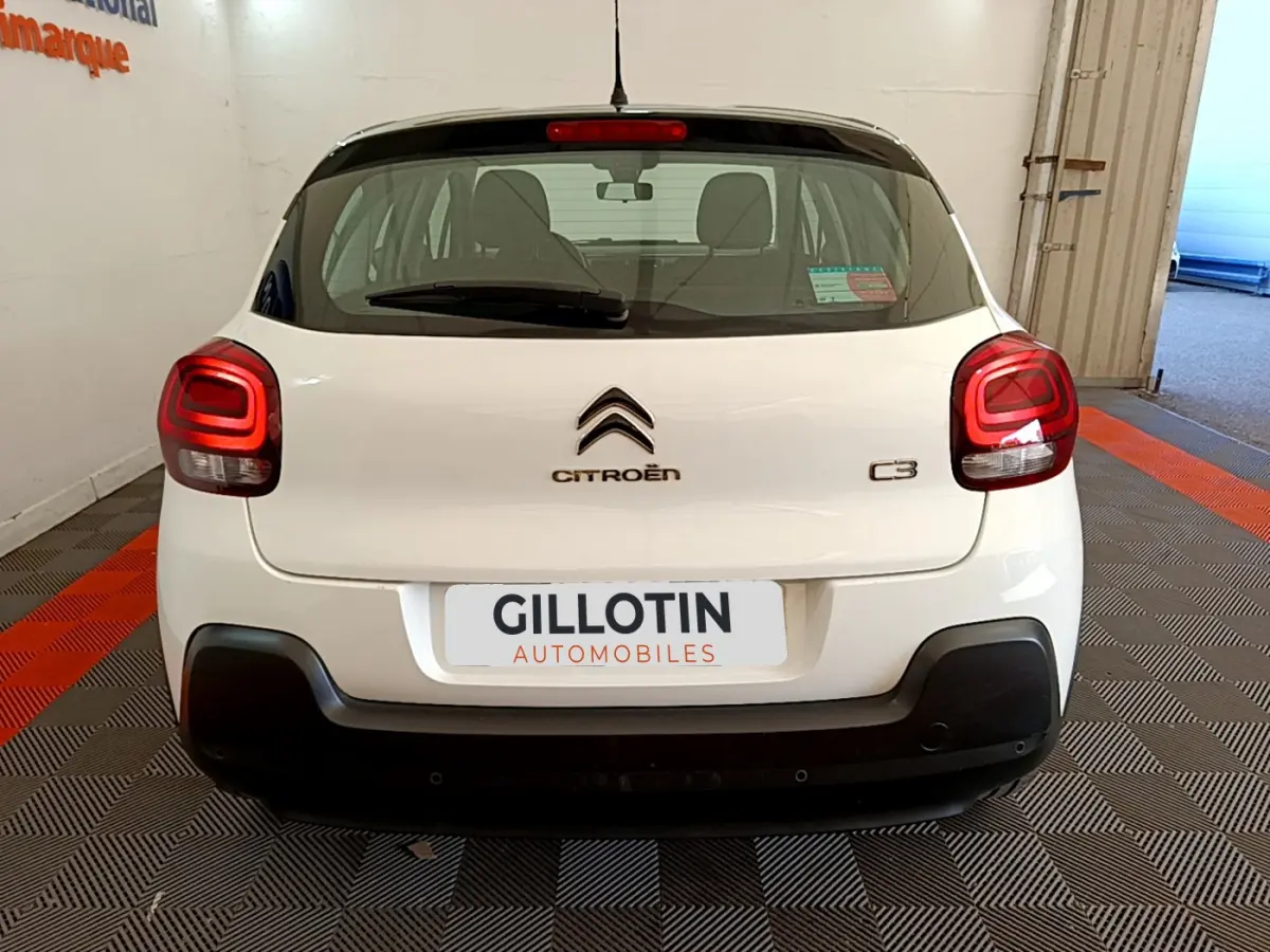 Vue arrière d'une Citroën C3 blanche de 2019 avec feux arrière distinctifs et logo centré sur un fond clair.