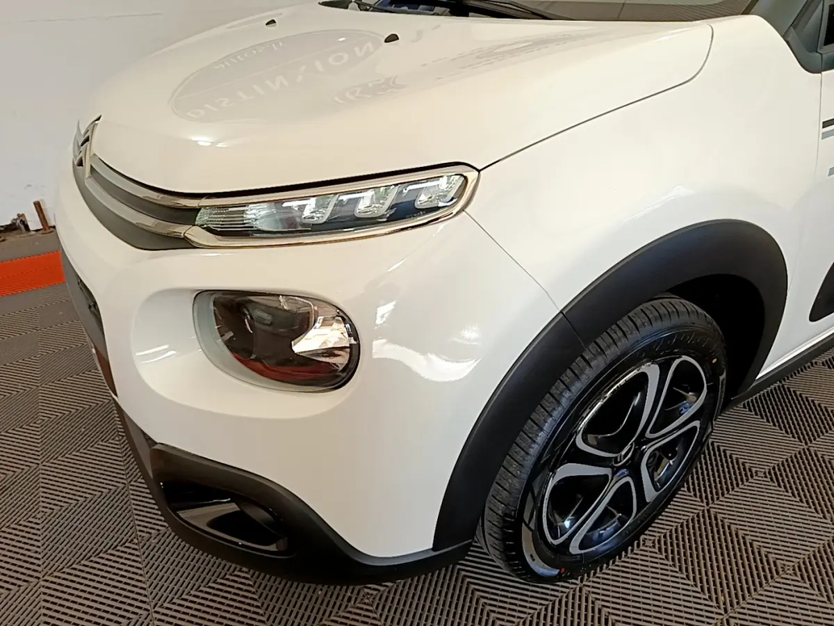 Gros plan sur l'avant droit blanc de la Citroën C3 2019 avec phares LED et jante noire à motifs distinctifs.
