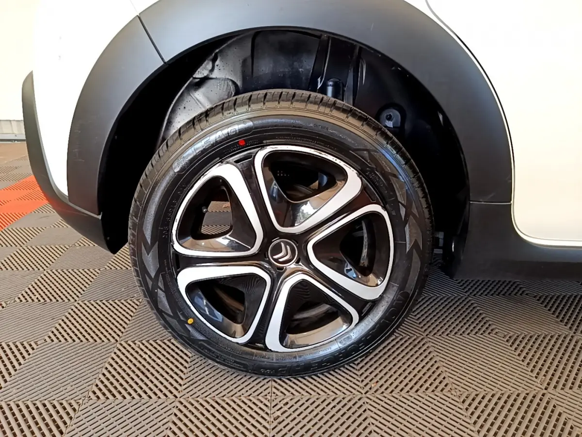 Gros plan sur la roue avant droite de la Citroën C3 blanche, mettant en valeur la jante noire et argentée au design moderne.