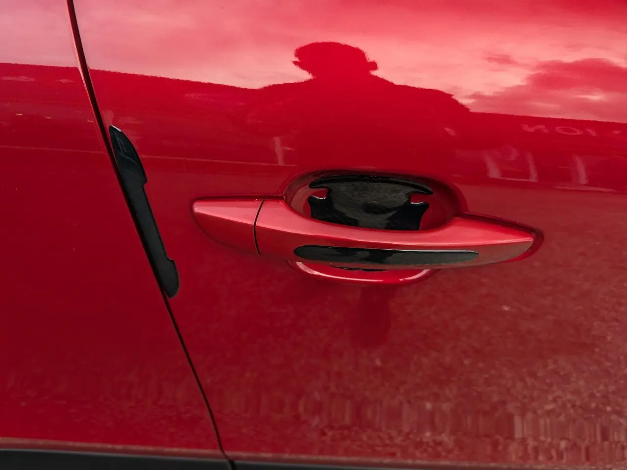 Poignée de porte côté gauche rouge foncé avec insert noir sur Citroën C4 2024 version Max.