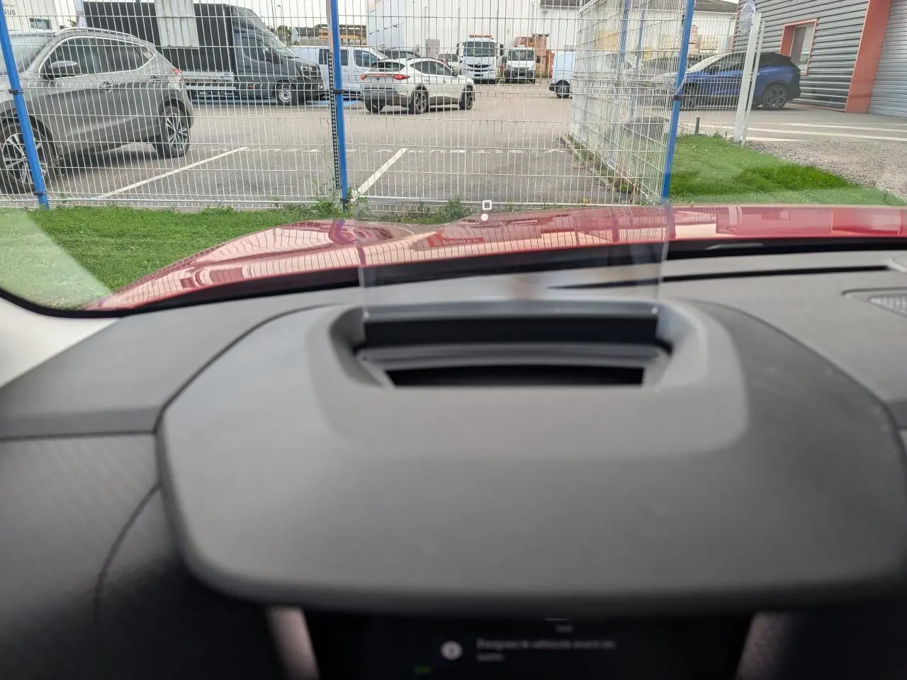 Affichage tête haute transparent sur le tableau de bord d'une Citroën C4 rouge foncé vue de l'intérieur avant.