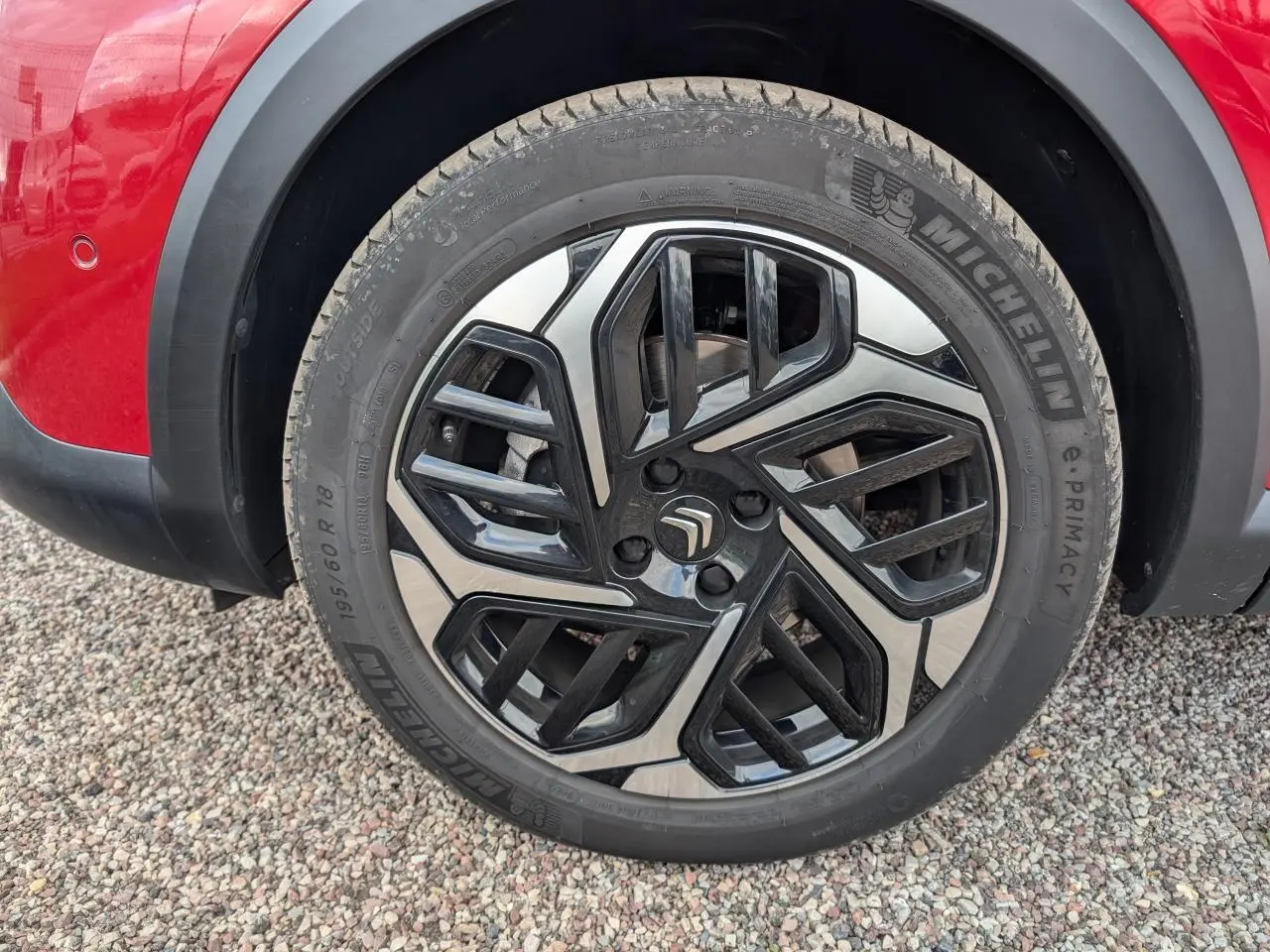 Gros plan sur la jante alliage 18'' Aeroblade noire et argentée du côté gauche d'une Citroën C4 rouge foncé 2024.