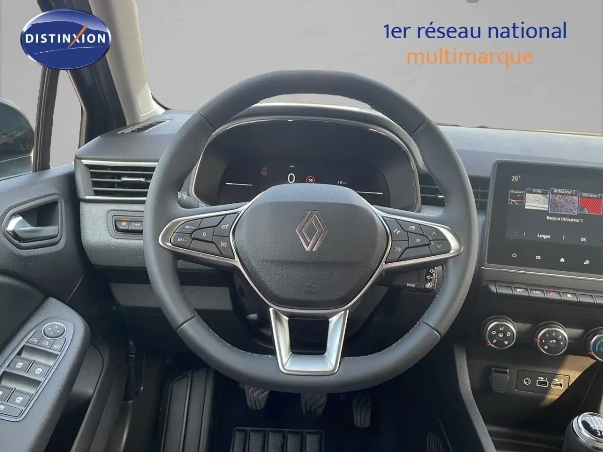 Vue intérieure centrée sur le volant Renault Clio 2025, tableau de bord et écran tactile avec commandes intégrées.