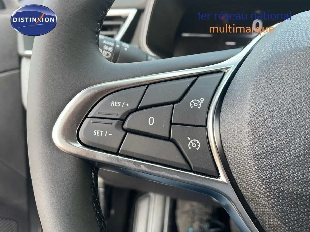 Gros plan sur les commandes de régulateur de vitesse au volant cuir noir de la Renault Clio Evolution Blue dCi 2025.