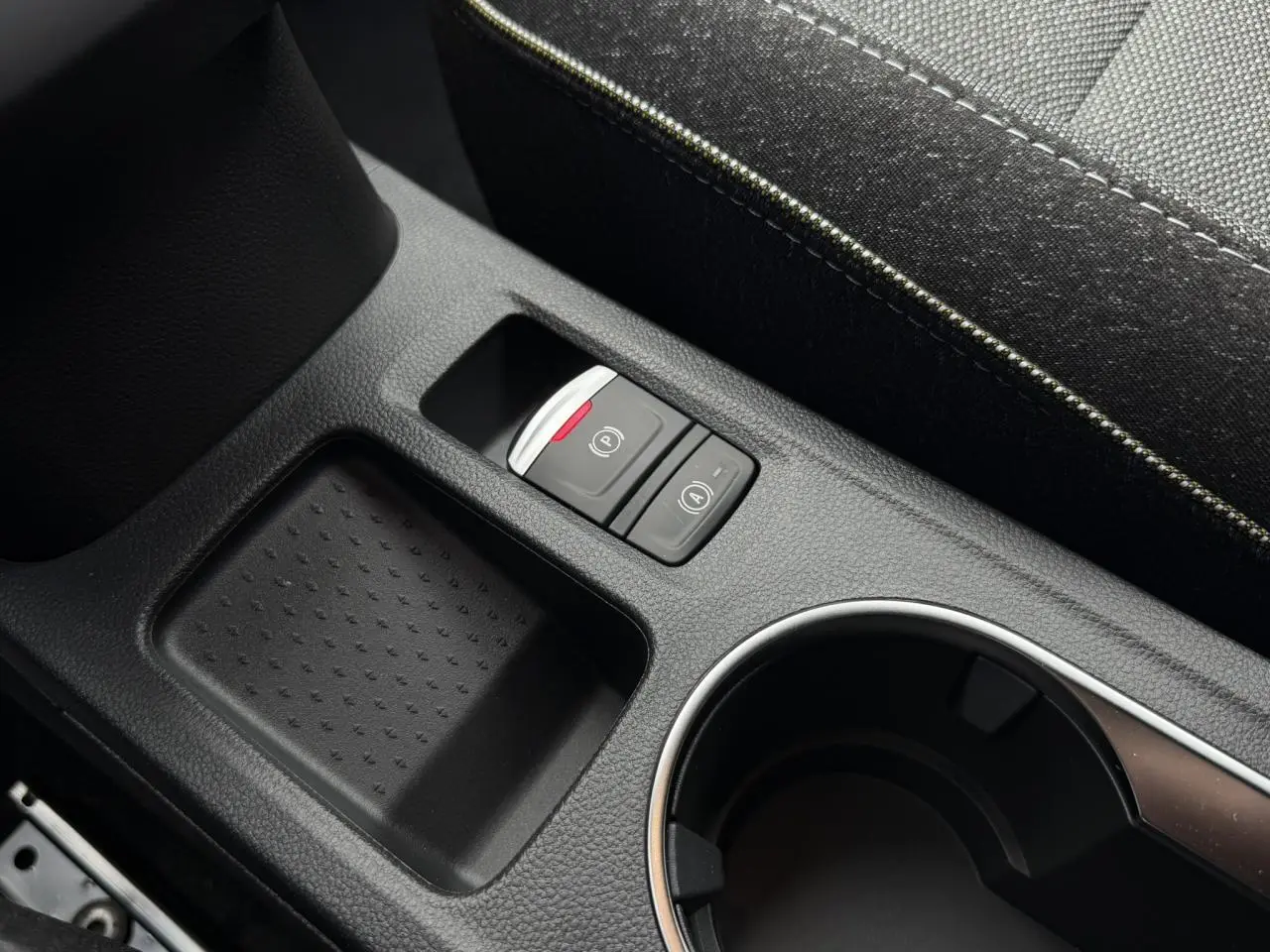 Gros plan sur la console centrale noire du Renault Captur 2026 avec boutons frein électrique et auto-hold.