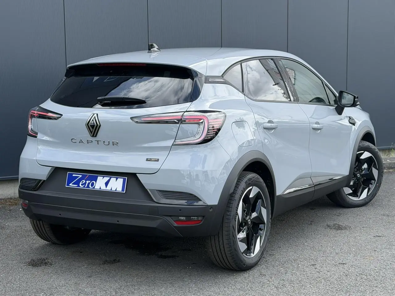 Vue 3/4 arrière droite du Renault Captur gris Rafale avec jantes aluminium noires et vitres surteintées.