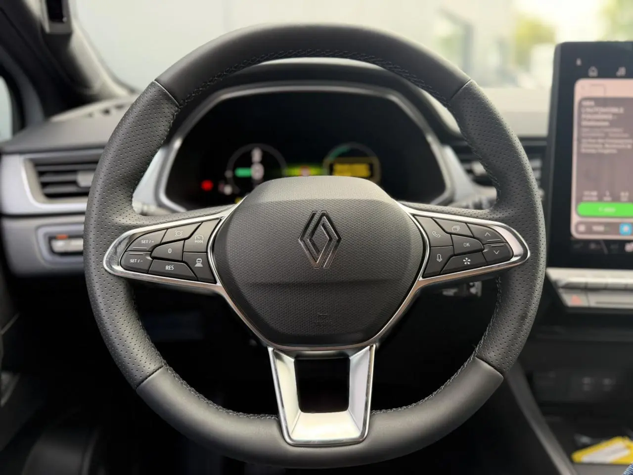 Volant en cuir noir avec commandes intégrées et logo Renault, vue frontale de l'intérieur du Renault Captur 2026.