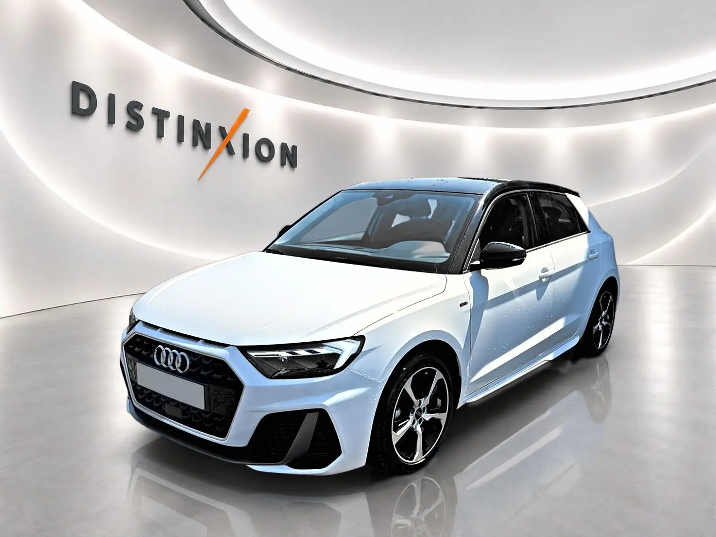 Audi A1 Sportback blanc et noir vue 3/4 avant droit avec jantes alliage et toit noir brillant dans showroom.