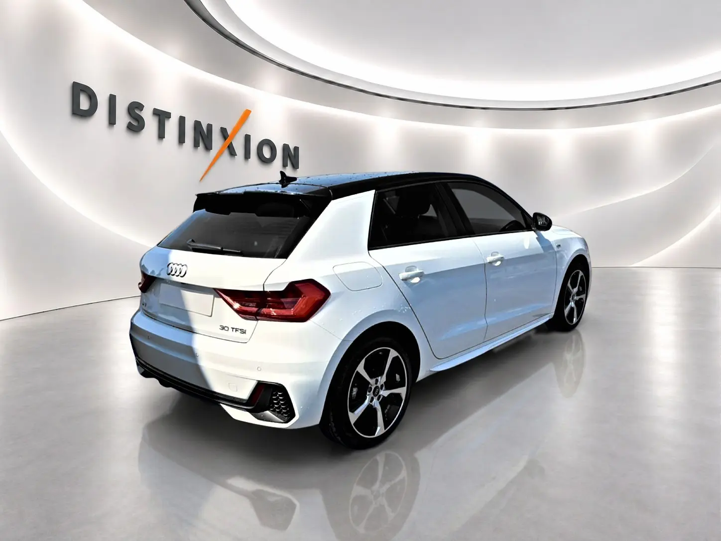 Audi A1 Sportback blanc toit noir en 3/4 arrière droit, avec jantes alliage et becquet arrière sportif.