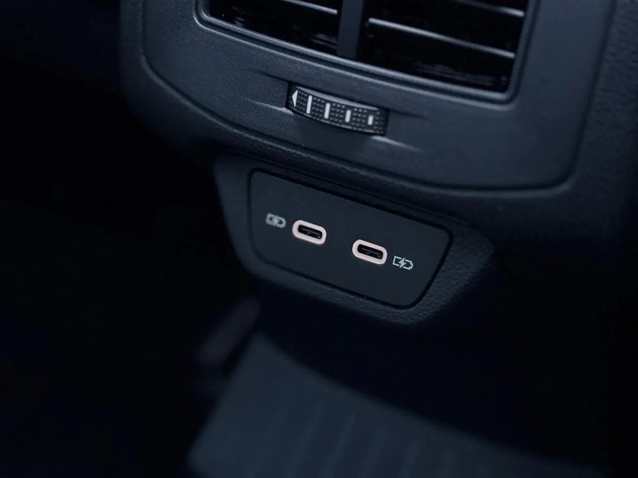 Prise USB-C double en gros plan à l'arrière d'un Volkswagen T-Roc 2025 gris Pyrite avec intérieur noir.