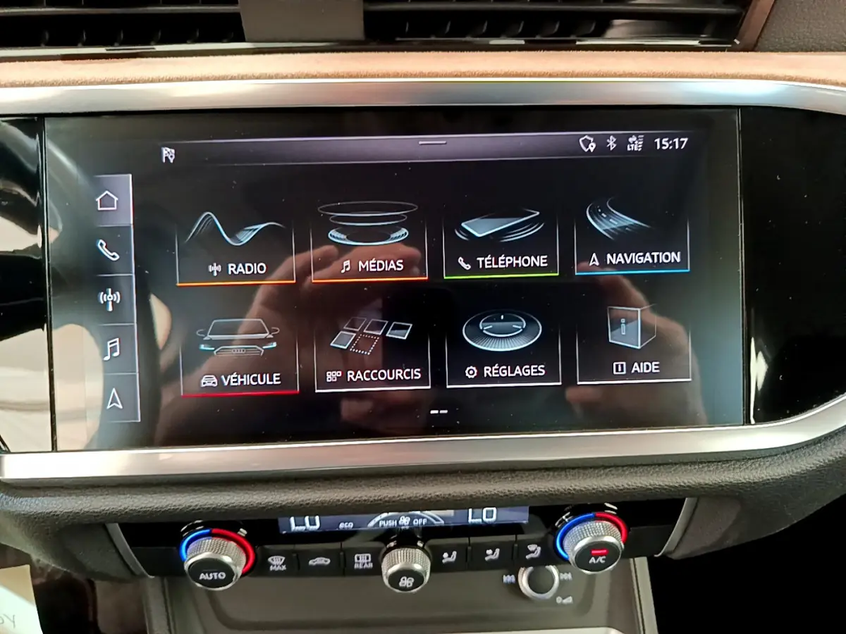 Écran tactile central affichant les menus multimédias et navigation dans l'habitacle d'un Audi Q3 35 TDI bleu.