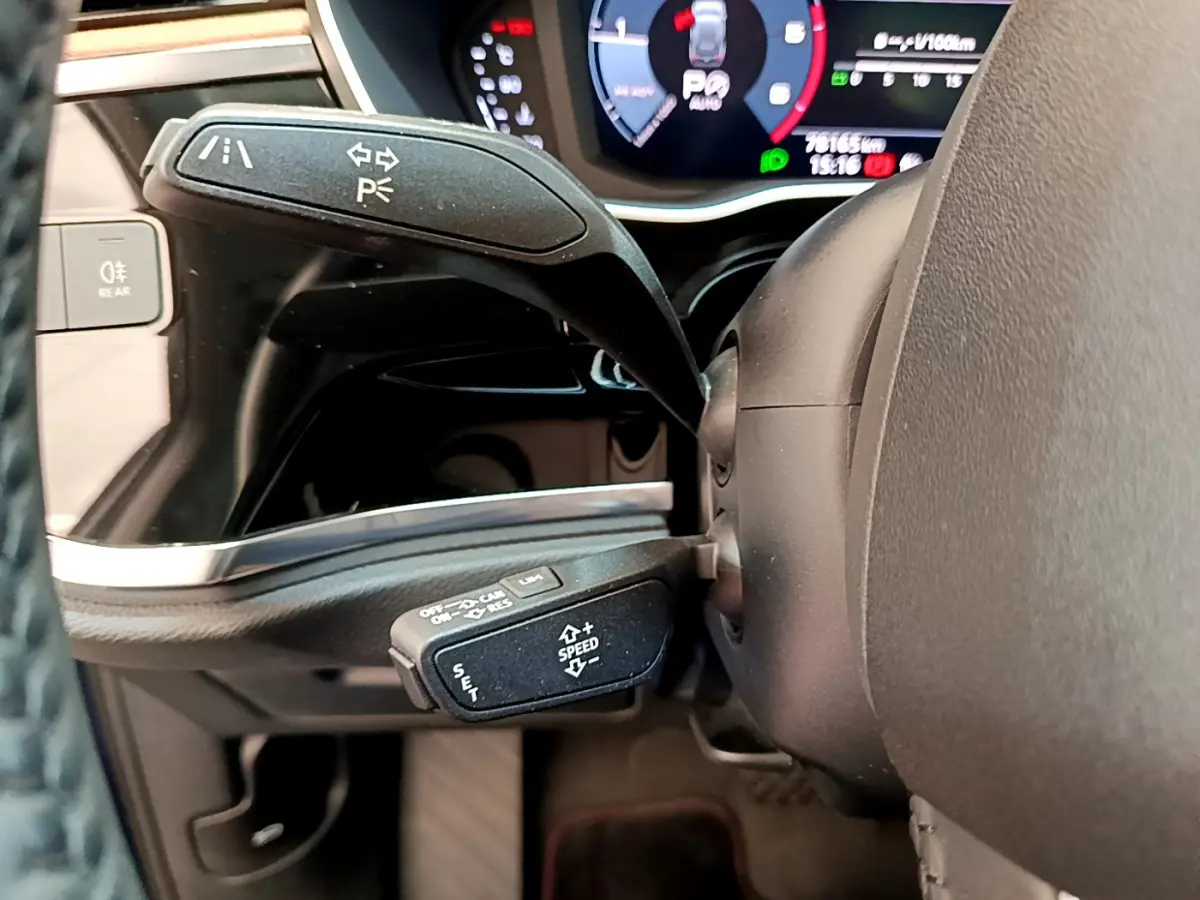 Gros plan sur le levier de commande multifonction et le tableau de bord numérique de l'Audi Q3 35 TDI bleu 2020.