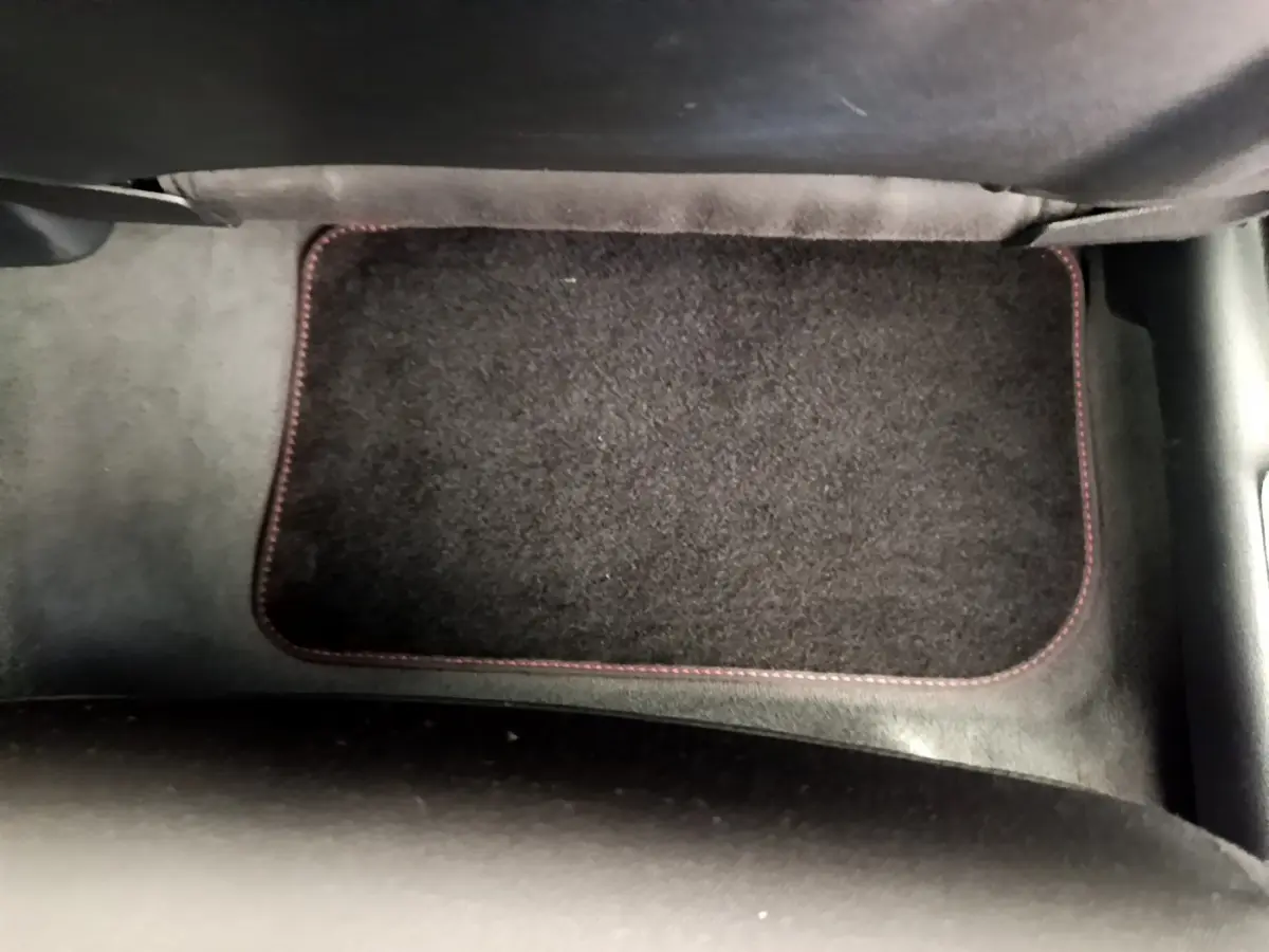 Tapis de sol noir avec surpiqûres rouges dans l'habitacle d'un Audi Q3 bleu 2020, vue du plancher côté passager.