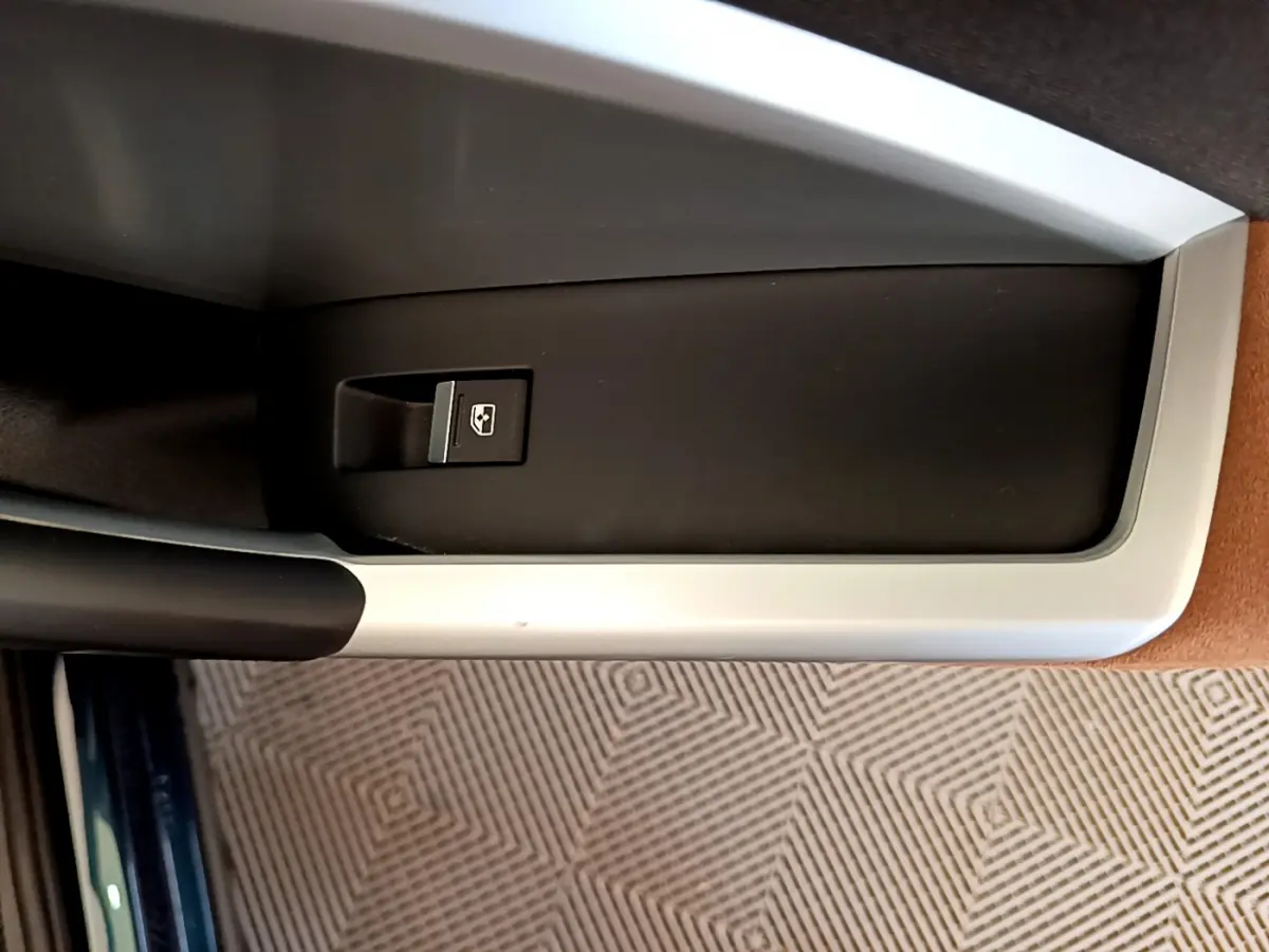 Bouton de commande de lève-vitre sur la porte intérieure côté conducteur d'un Audi Q3 bleu 2020.