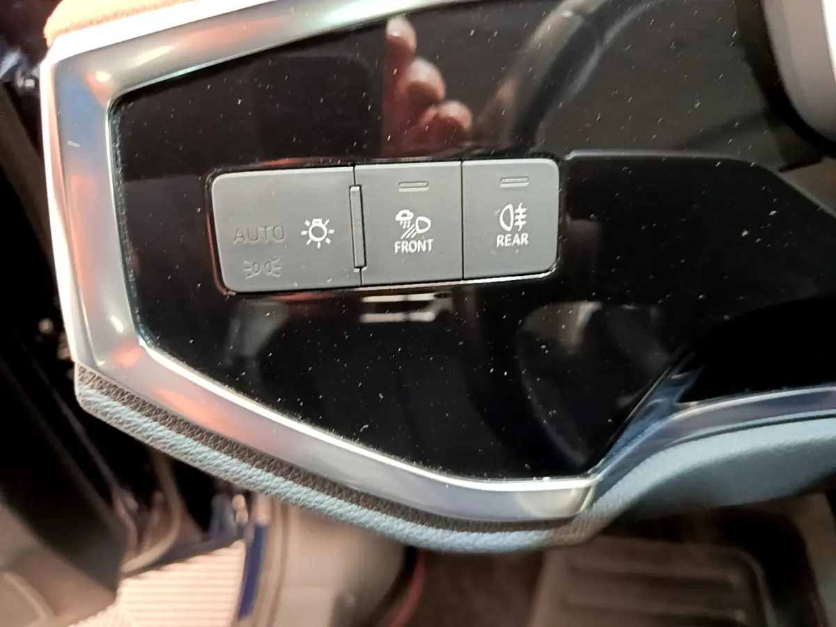 Gros plan sur les commandes d'éclairage du tableau de bord de l'Audi Q3 35 TDI bleu, version Business Line 2020.