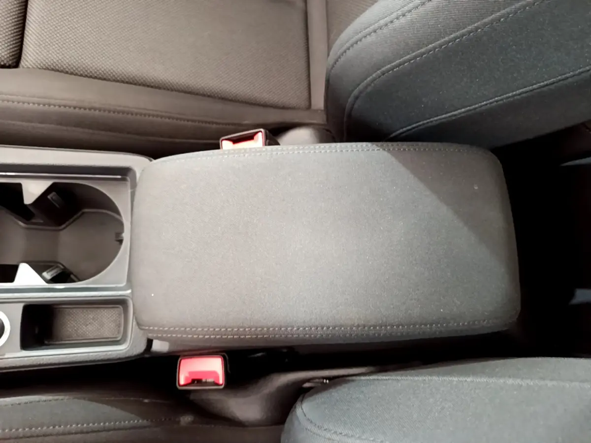 Vue rapprochée de l'accoudoir central et porte-gobelets noirs à l'intérieur de l'Audi Q3 bleu 2020.