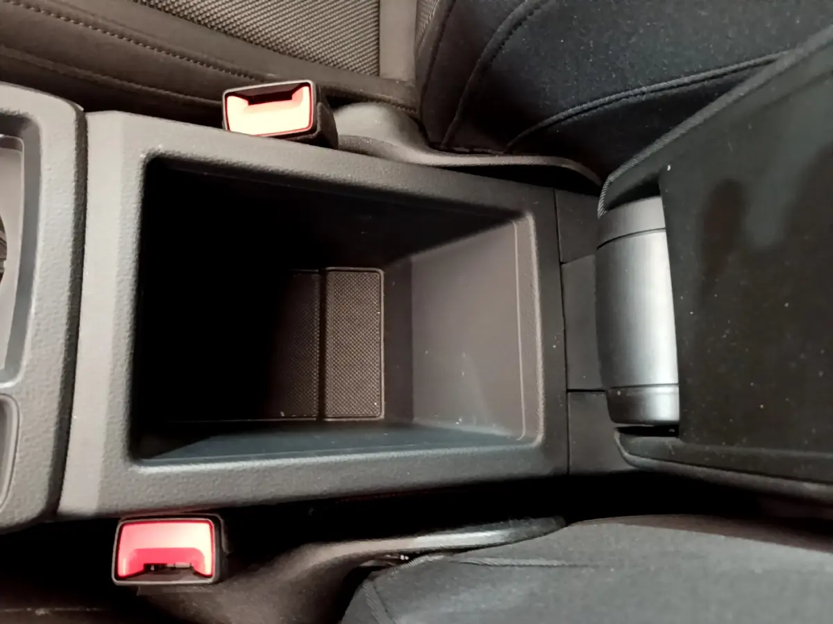 Gros plan sur le rangement central noir entre les sièges avant d'un Audi Q3 bleu 35 TDI 150 S Tronic Business Line.