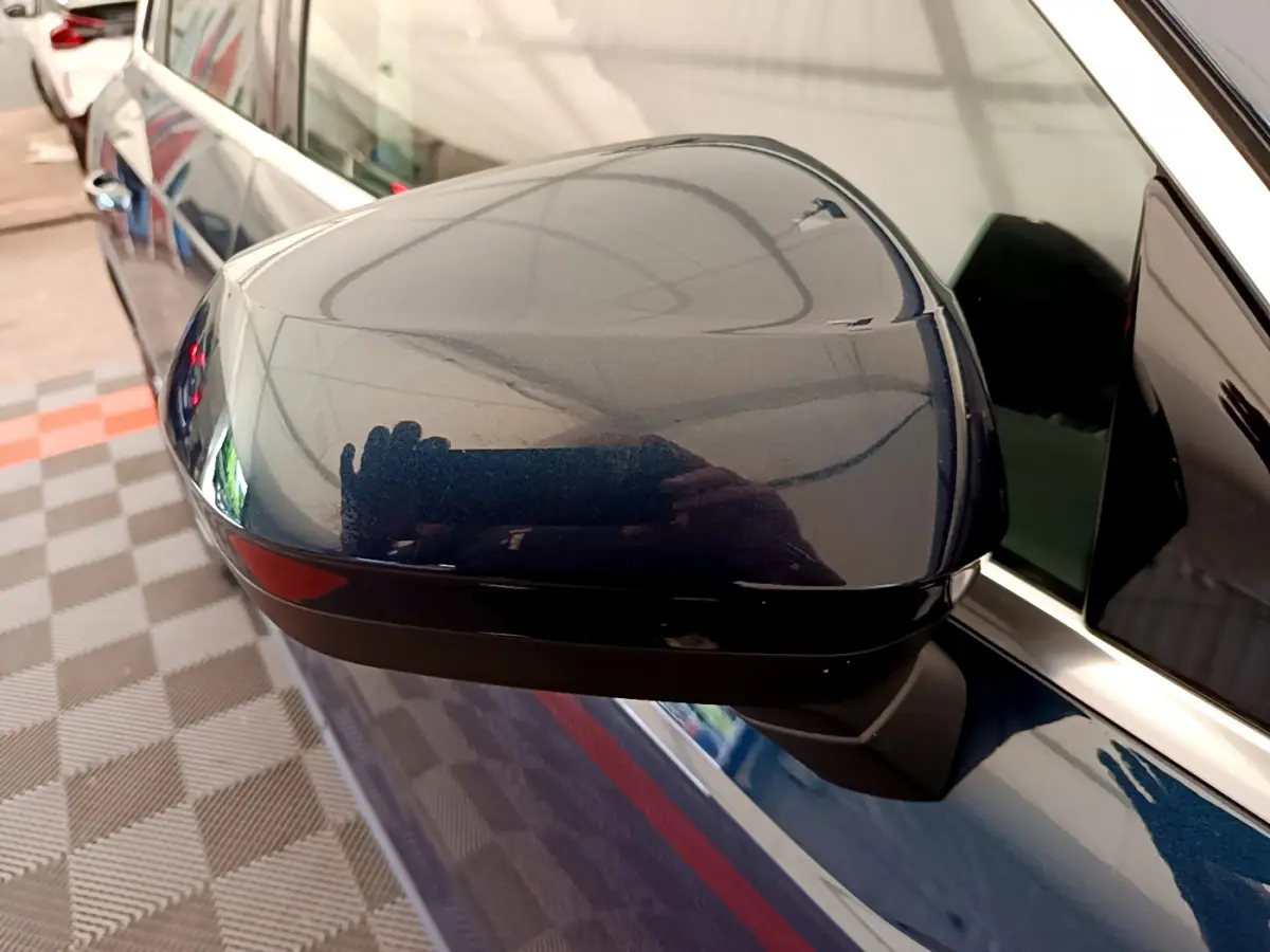 Rétroviseur côté gauche bleu métallisé de l'Audi Q3 35 TDI 150 S tronic Business Line 2020 avec clignotant intégré.