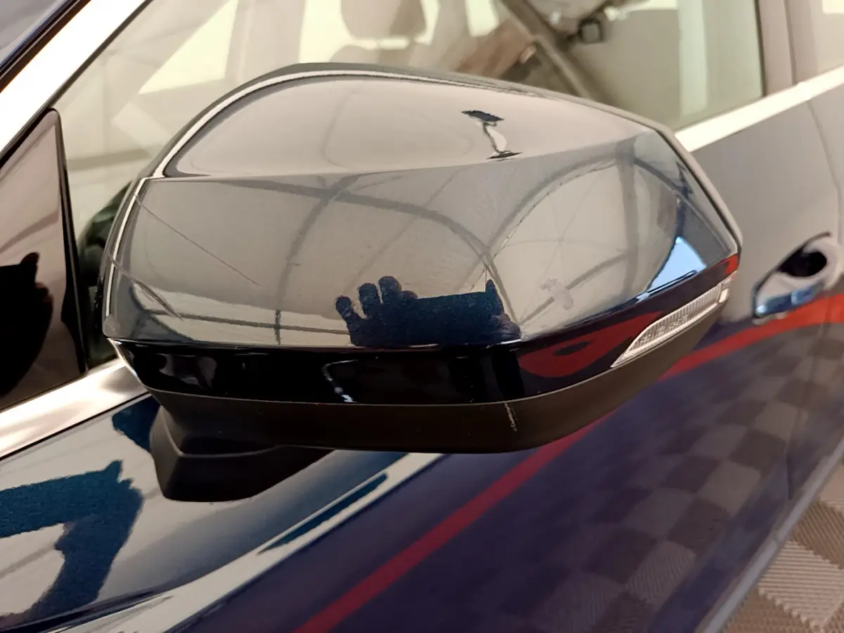 Rétroviseur côté gauche bleu foncé de l'Audi Q3 35 TDI 150 S tronic Business Line avec clignotant intégré.