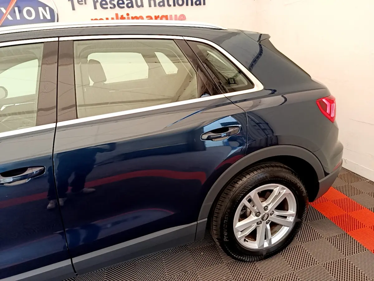 Vue latérale côté droit d'un Audi Q3 bleu 2020 avec jante alliage et feux arrière LED visibles.