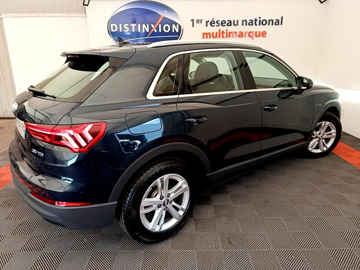 Audi Q3 bleu 35 TDI vue 3/4 arrière côté droit, avec feux arrière LED et jantes alliage argentées.