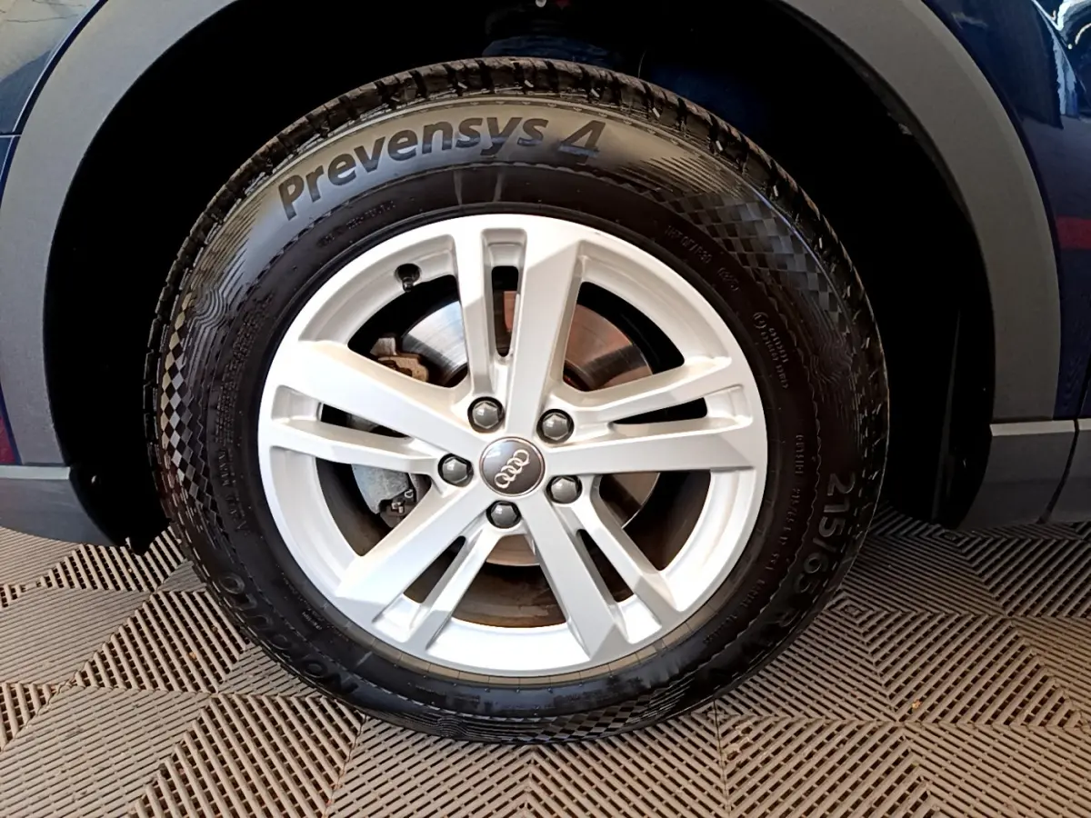 Gros plan sur la roue avant droite d’un Audi Q3 bleu 2020 avec jante argentée et pneu Prevensys 4 visible.