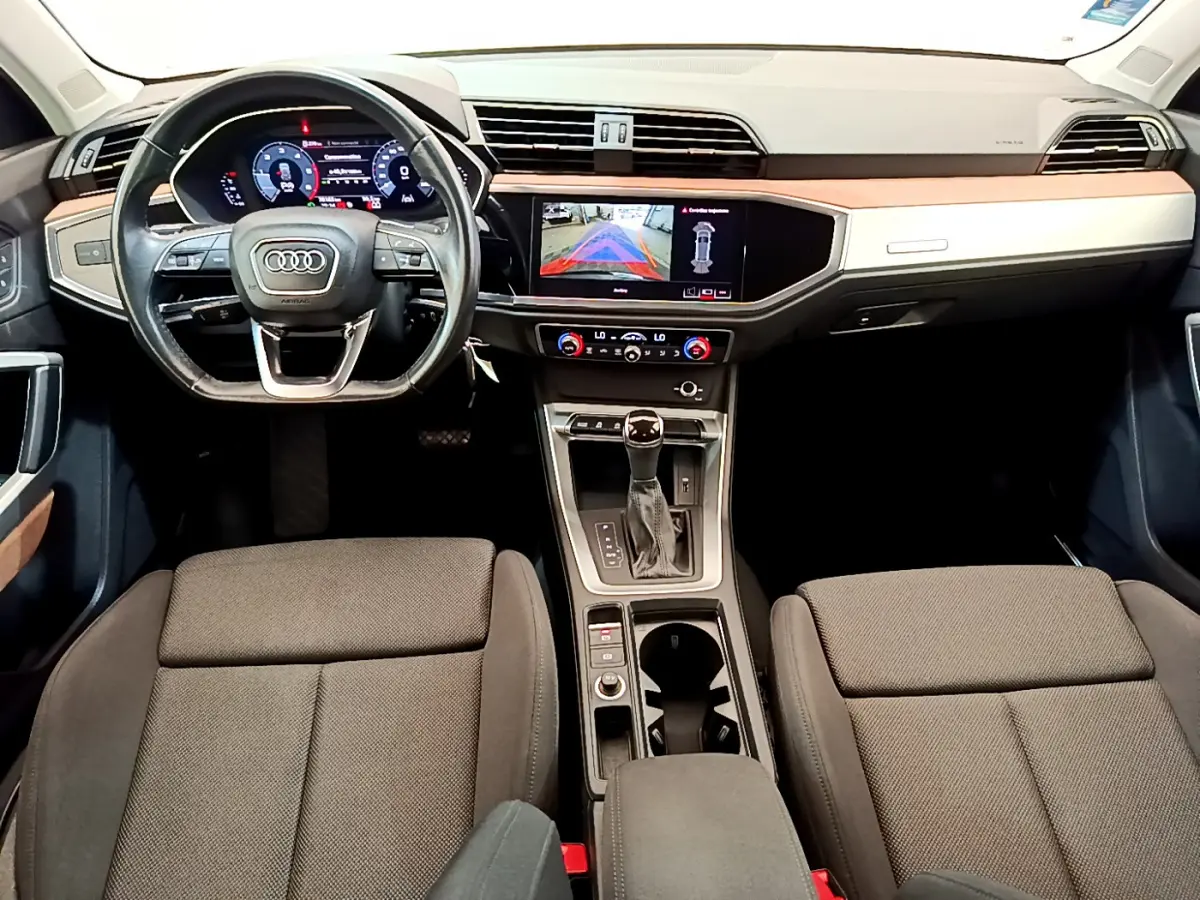 Intérieur Audi Q3 2020 vue de face, tableau de bord noir avec écran tactile et volant cuir multifonctions.