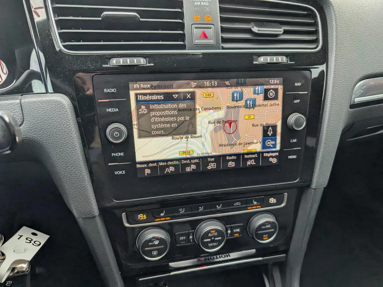 Vue rapprochée de la console centrale noire de la Volkswagen Golf R 2017 avec écran de navigation et commandes de climatisation.